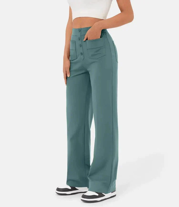 Frau trägt weite, grüne Hose mit Taschen und Knöpfen, kombiniert mit weißem Crop-Top und Sneakers. Modetrend, Damenbekleidung, lässiger Stil.