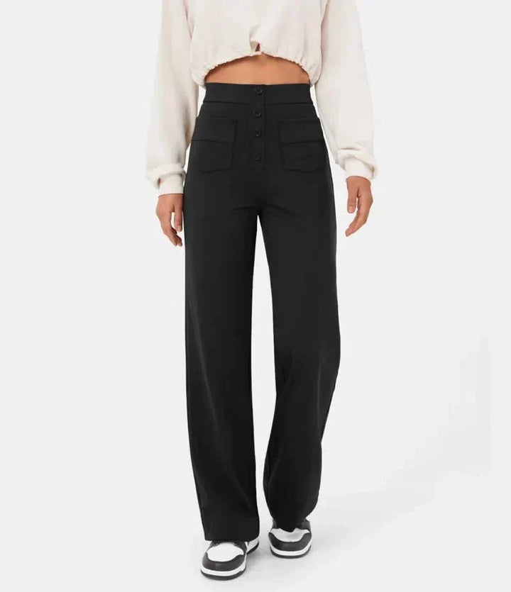 Damenhose Schwarz, High-Waist, weites Bein, Knopfleiste, Taschen, kombiniert mit weißem Crop-Top und Sneakers. Modetrend, lässiger Stil.
