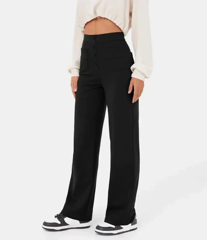Damenhose schwarz, hoch tailliert, mit weitem Bein und Knopfleiste, kombiniert mit weißem Oberteil und Sneakers. Modetrend 2023, lässiger Stil.