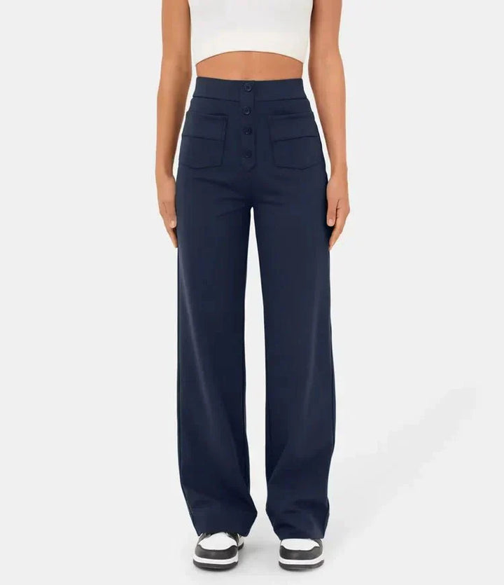 Dunkelblaue, hoch taillierte Damenhose mit weitem Bein und Knopfleiste, getragen von Frau in weißem Top. Modetrend, elegante Damenbekleidung.