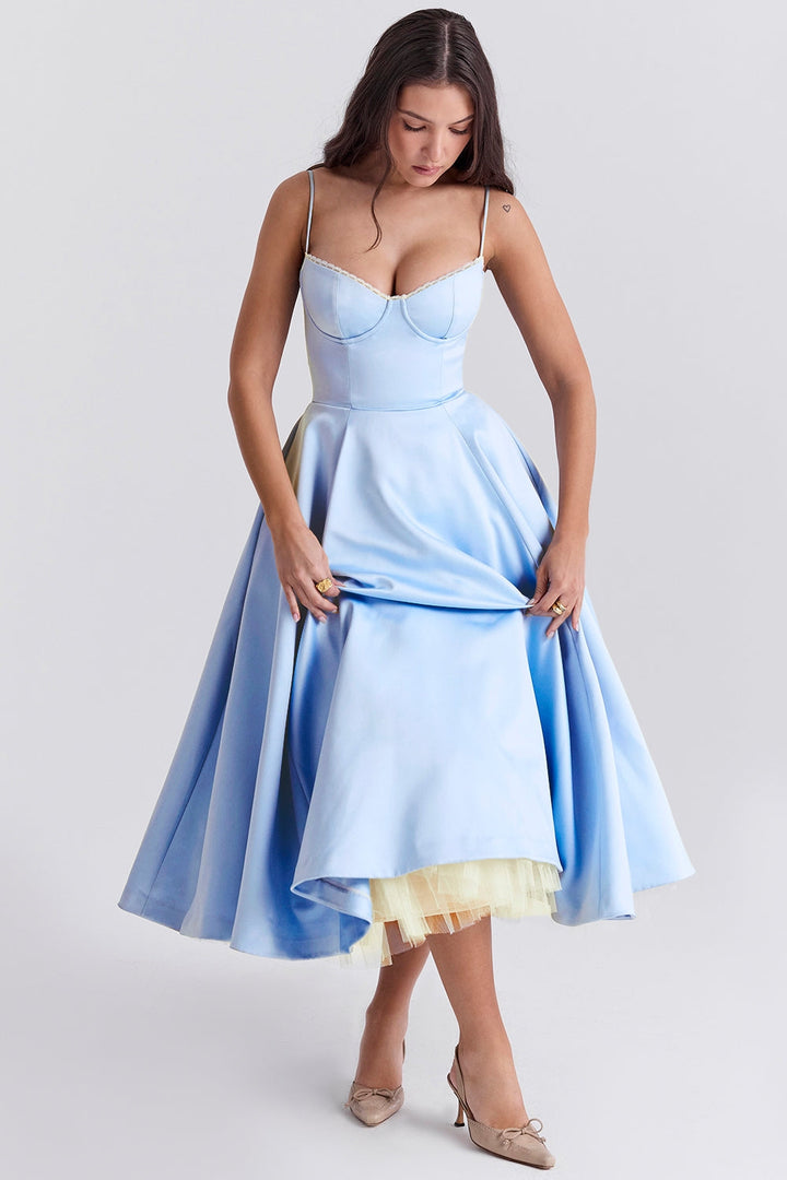 Frau in hellblauem Abendkleid mit Spaghettiträgern, gelbem Unterrock und beigen Schuhen. Elegantes Ballkleid, Mode, Abendmode.