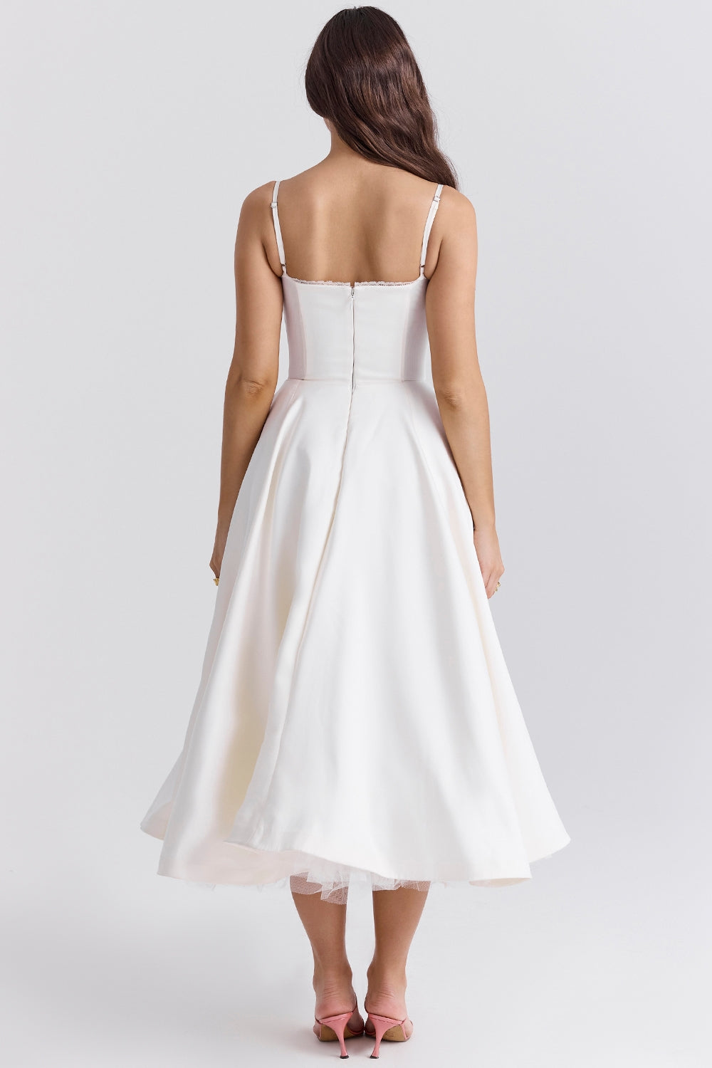 Frau in weißem, ärmellosem Midikleid mit Spaghettiträgern, Rückansicht. Elegantes Design, ideal für Sommermode und festliche Anlässe.