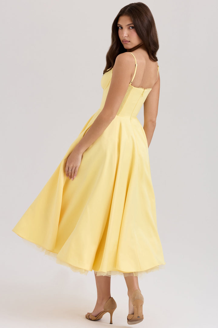 Frau in gelbem, schulterfreiem Kleid, das bis zur Wade reicht, mit beigen High Heels. Elegantes Abendkleid, Mode, Damenbekleidung, stilvoll.
