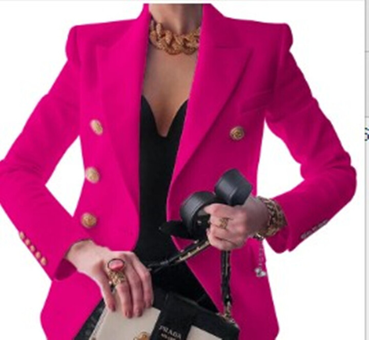 Frau in pinkem Blazer mit goldenen Knöpfen, hält Prada-Tasche und Kopfhörer. Elegante Mode, Luxusaccessoires, stilvolles Outfit.