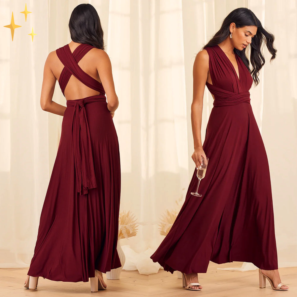 Frau in elegantem, langem, weinrotem Abendkleid mit Wickeloptik, hält ein Glas Sekt. Perfekt für festliche Anlässe und elegante Veranstaltungen.