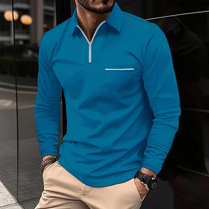 Mann in blauem Langarm-Poloshirt mit Reißverschluss und Brusttasche, beige Hose, Armbanduhr, städtischer Hintergrund. Herrenmode, Freizeitlook.