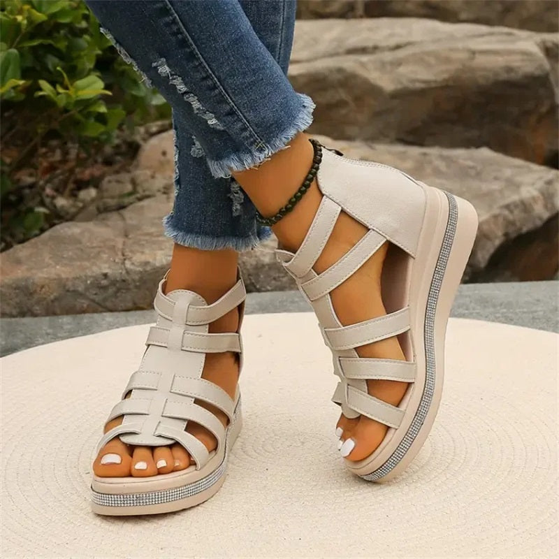 Damen Sandalen mit Keilabsatz, beige, Kreuzriemen-Design, getragen mit zerrissenen Jeans, Outdoor-Hintergrund, modische Sommermode.