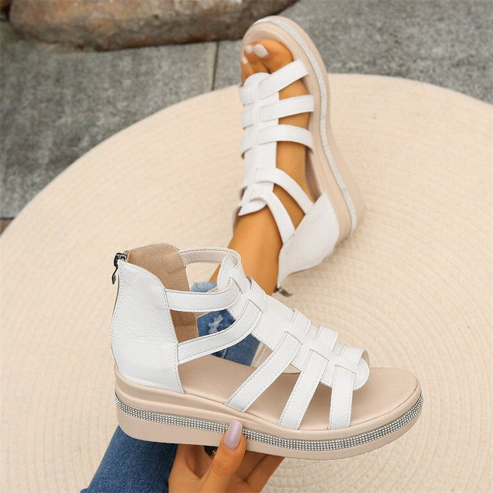 Weiße Damen-Sandalen mit Keilabsatz und Riemchen-Design, ideal für Sommermode. Bequeme, stilvolle Schuhe auf hellem Hintergrund.