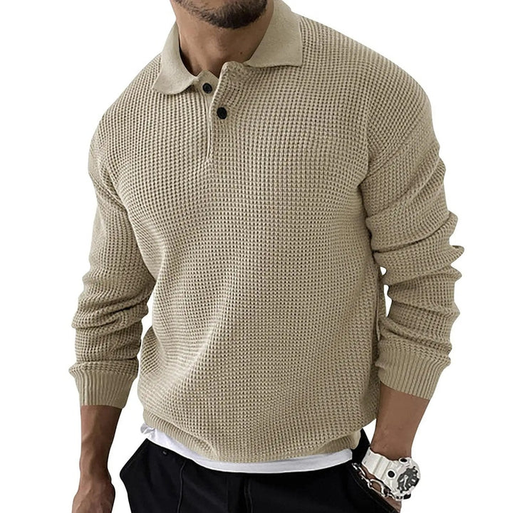 Beiger Strickpullover für Herren mit Kragen und Knopfleiste, kombiniert mit schwarzer Hose. Modischer Herrenpullover, ideal für Herbstmode.