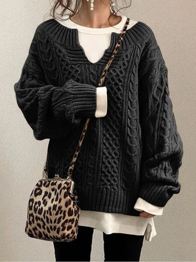 Dunkelgrauer Strickpullover mit Zopfmuster, kombiniert mit weißem Shirt und Leopardenmuster-Tasche. Modischer Herbst-Look für Damen.