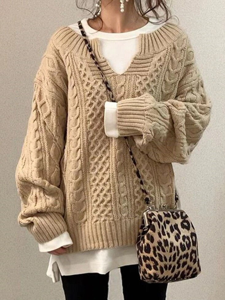 Frau in beigem Strickpullover mit Zopfmuster, weißem Shirt und Leopardenmuster-Tasche. Modetrend Herbst/Winter, lässiger Stil.