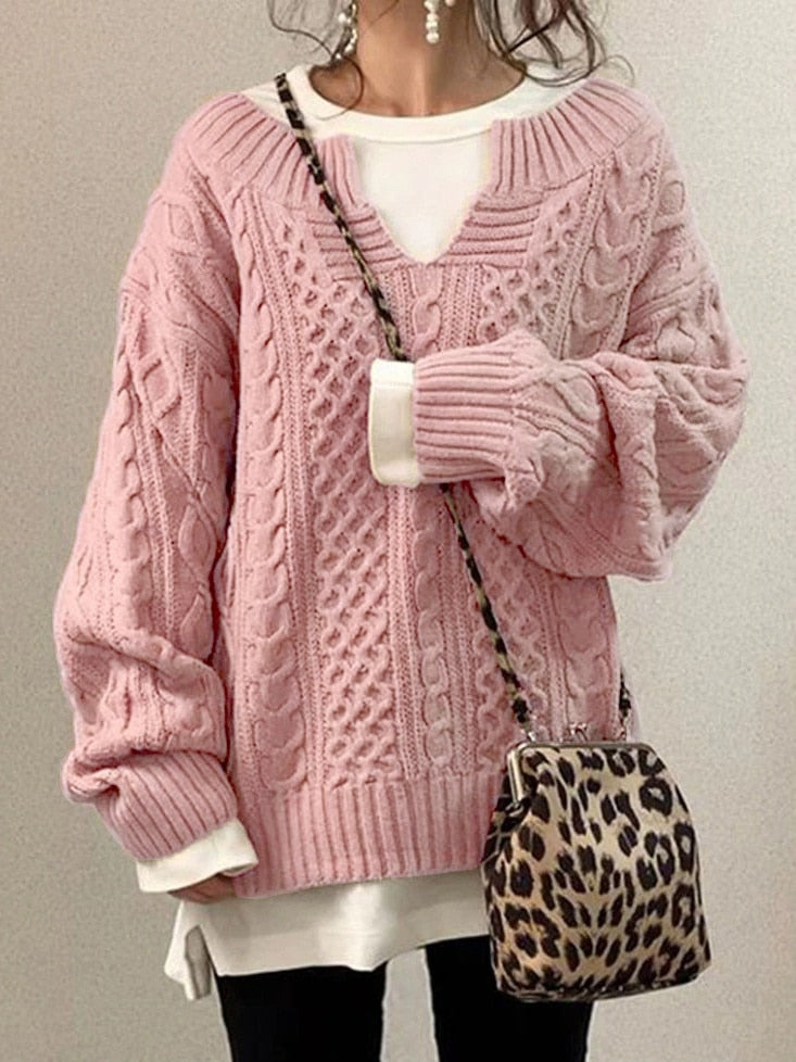 Frau in rosa Strickpullover mit Zopfmuster, weißem Shirt darunter, Leopardenmuster-Tasche, modisch, gemütlich, Herbstmode, Damenbekleidung.