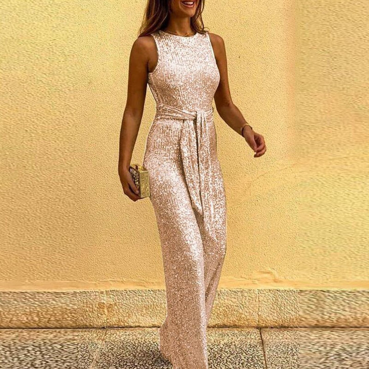 Frau in elegantem, ärmellosem, bodenlangem Paillettenkleid in Beige, hält eine goldene Clutch. Perfekt für Abendveranstaltungen und Partys.