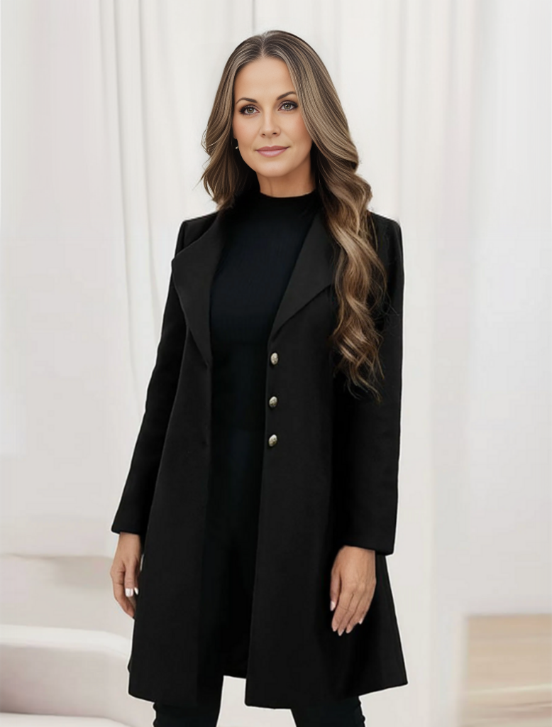Frau in elegantem schwarzen Mantel mit langen Ärmeln und Knöpfen, stehend vor hellem Hintergrund. Mode, Damenbekleidung, stilvoller Look.