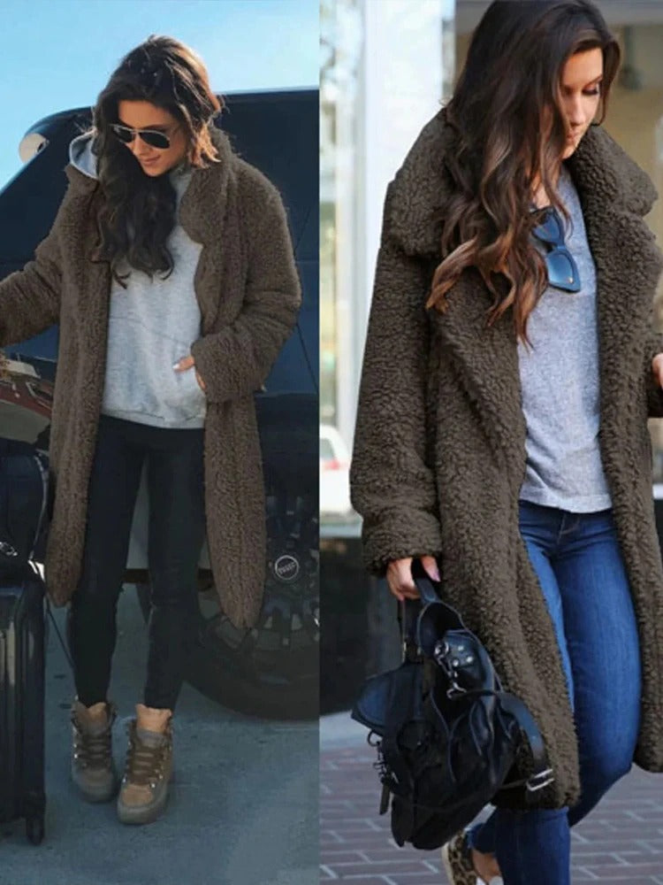 Frau in braunem Teddy-Mantel, grauem Pullover und Jeans, trägt Sonnenbrille und schwarze Tasche. Modetrend, Wintermode, lässiger Look.