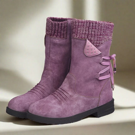 Lila Damenstiefel mit Strickbündchen, dekorativen Schleifen und Nieten, rutschfeste Sohle. Modische Winterstiefel für Damen.