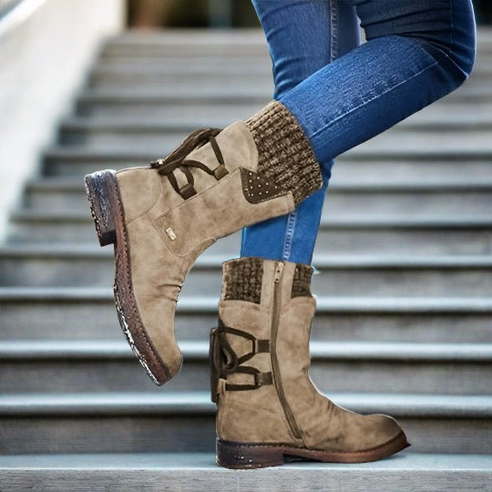 Damenstiefel aus Wildleder in Beige mit Strickbündchen und Reißverschluss, kombiniert mit blauen Jeans auf einer Treppe. Modische Herbst-Winter-Schuhe.