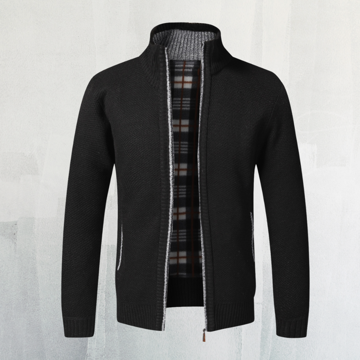 Schwarze Strickjacke mit Reißverschluss, kariertem Innenfutter und Stehkragen vor hellem Hintergrund. Herrenmode, stilvoll, warm.