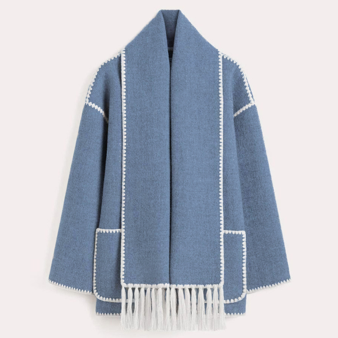 Blauer Wollmantel mit weißen Ziernähten und Fransen, offener Schnitt, zwei Taschen. Eleganter Damenmantel, ideal für Herbstmode.