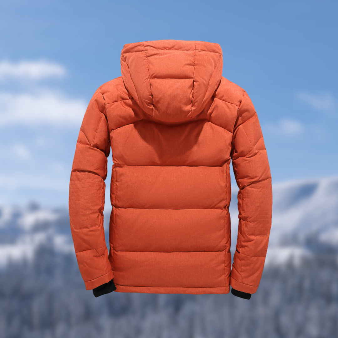 Orangefarbene Daunenjacke mit Kapuze vor winterlicher Berglandschaft. Perfekt für Outdoor-Aktivitäten und kaltes Wetter. Hochwertige Wintermode.