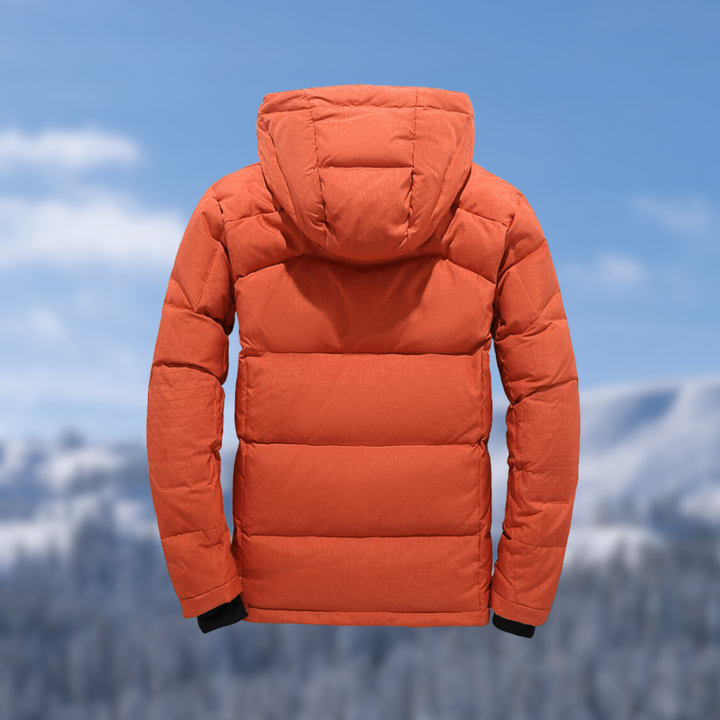 Orangefarbene Daunenjacke mit Kapuze vor winterlicher Berglandschaft. Perfekt für Outdoor-Aktivitäten und kaltes Wetter. Hochwertige Wintermode.