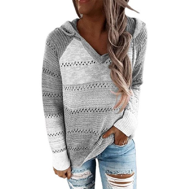 Frau in grauem Strickpullover mit Kapuze und zerrissenen Jeans. Modischer Herbst-Look, lässiger Stil, gemütlicher Strick, trendige Damenmode.