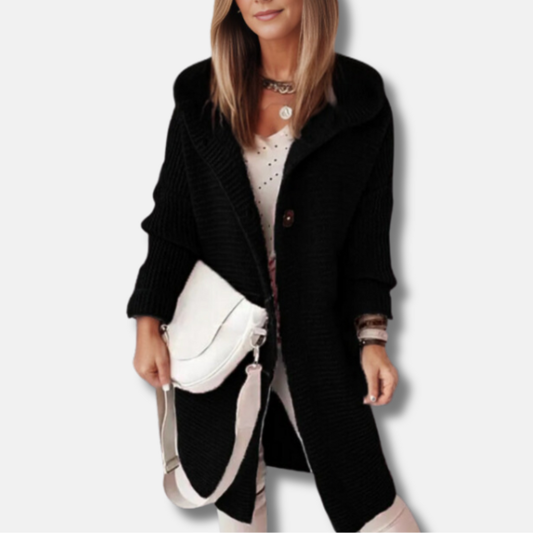 Frau in schwarzem Strickmantel mit weißer Umhängetasche, modisches Outfit, Herbstmode, eleganter Look, Damenbekleidung, stilvolle Accessoires.