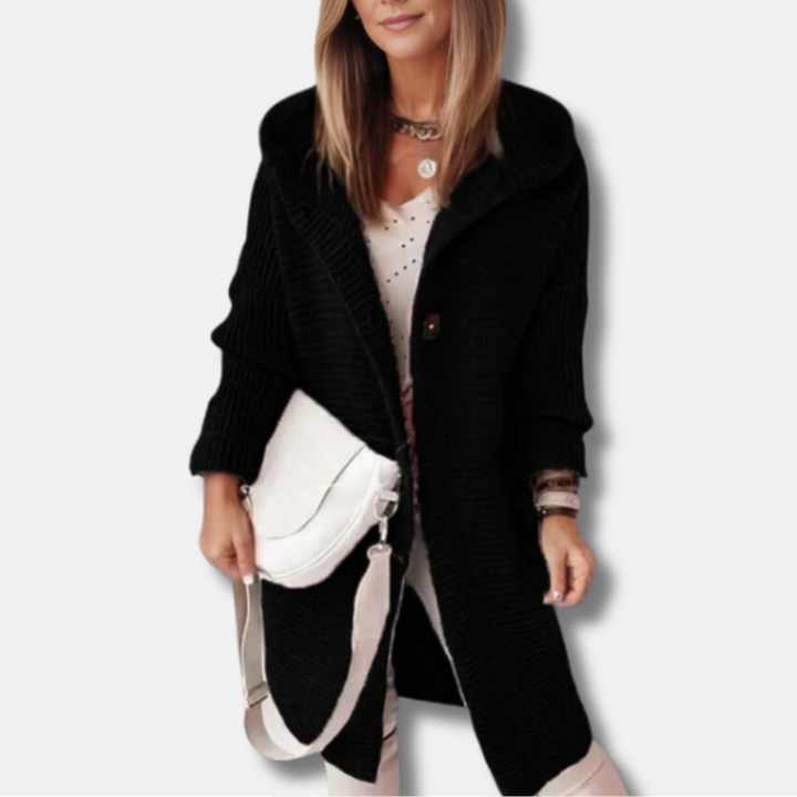 Frau in schwarzem Strickmantel mit weißer Umhängetasche, modisches Outfit, Herbstmode, eleganter Look, Damenbekleidung, stilvolle Accessoires.