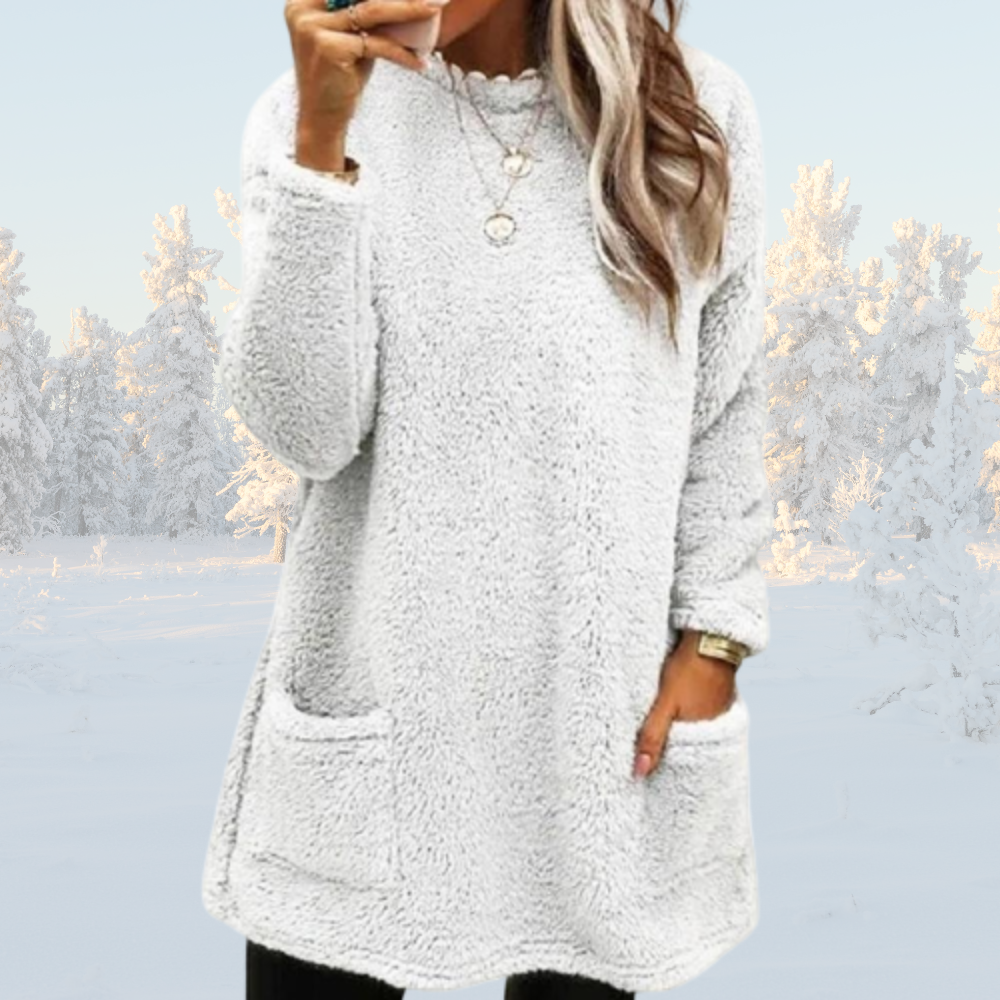 Frau in weißem, flauschigem Pullover mit Taschen, Winterlandschaft im Hintergrund. Modetrend, gemütlicher Look, Wintermode, Damenbekleidung.