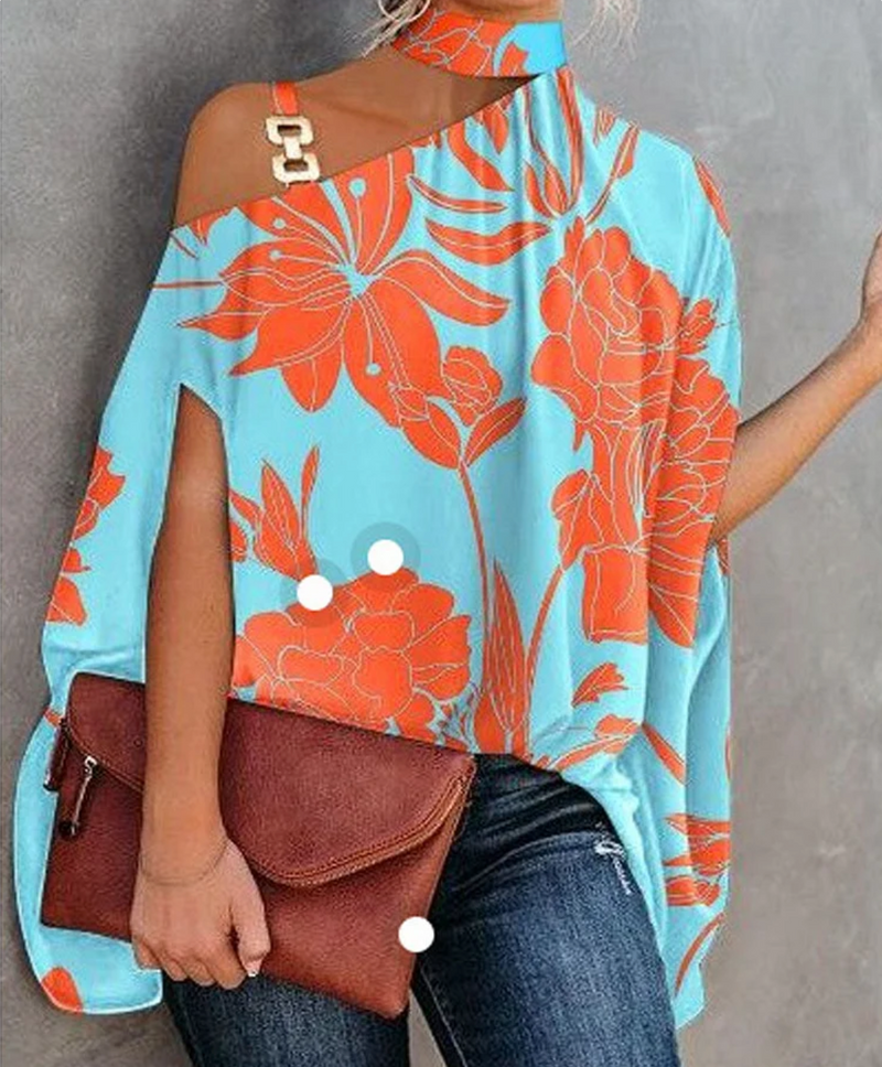 Frau in schulterfreiem, blauem Poncho mit orangefarbenem Blumenmuster, hält braune Lederhandtasche. Modetrend, Sommeroutfit, Damenmode.