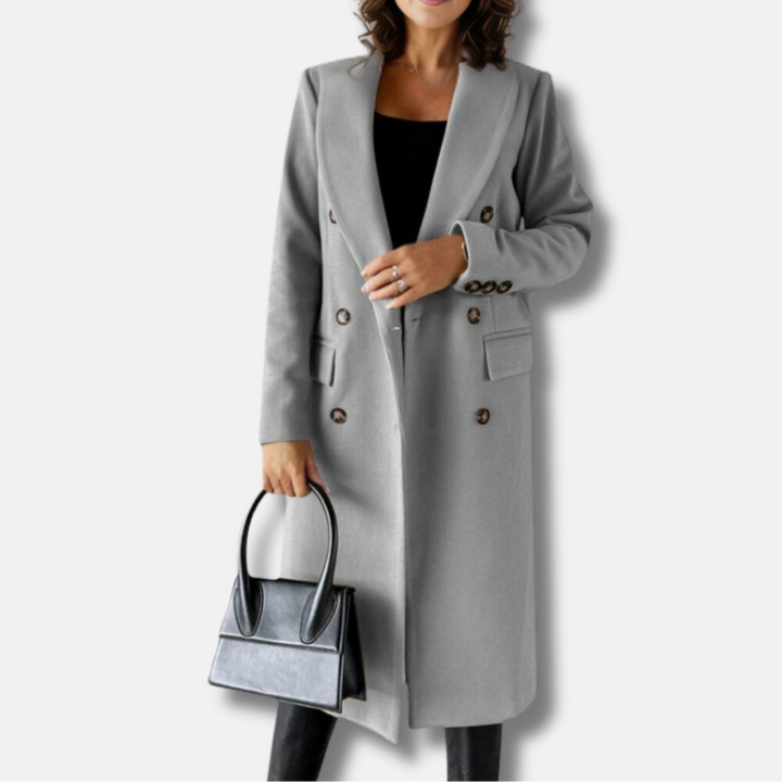 Frau in grauem Wollmantel mit doppelter Knopfleiste, hält schwarze Handtasche. Elegante Herbstmode, stilvoller Damenmantel, modisches Outfit.