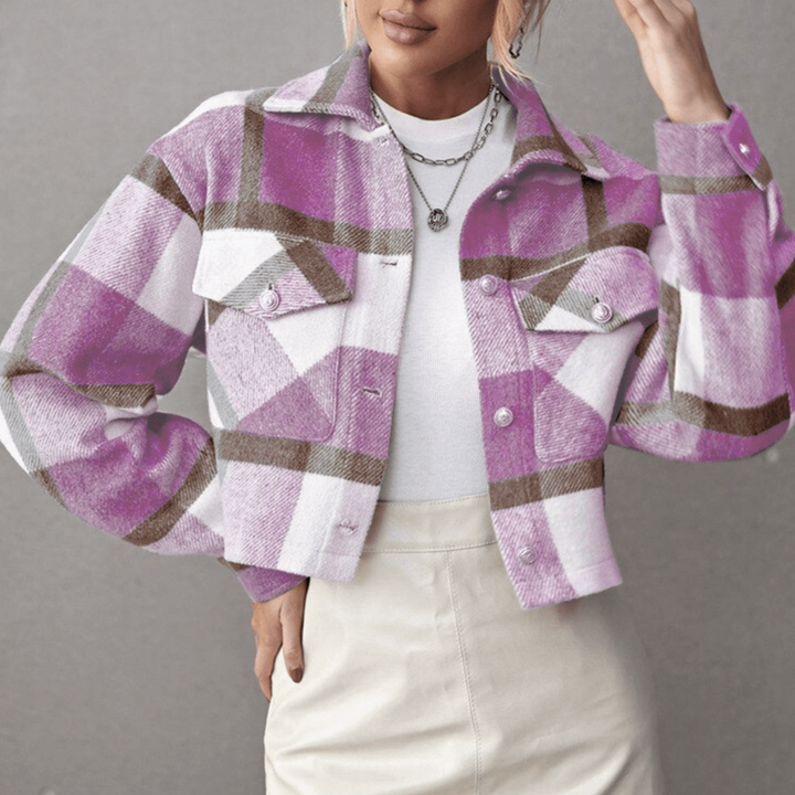 Frau trägt lila-weiß karierte Jacke, kombiniert mit weißem Oberteil und beigem Rock. Modetrend, Herbstmode, Damenjacke, stilvoller Look.