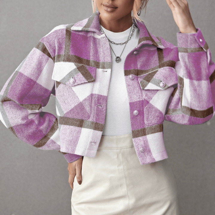 Frau trägt lila-weiß karierte Jacke, kombiniert mit weißem Oberteil und beigem Rock. Modetrend, Herbstmode, Damenbekleidung, stilvoll.