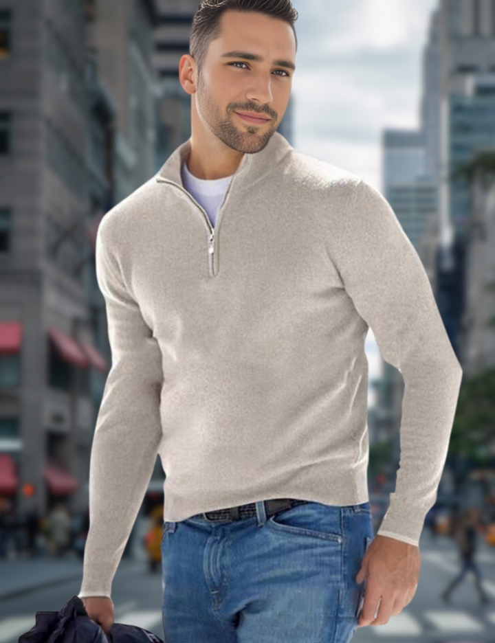 Ein Mann in einem beigen Pullover mit Reißverschluss und blauer Jeans geht durch eine belebte Stadtstraße. Mode, Herrenbekleidung, urbaner Stil.