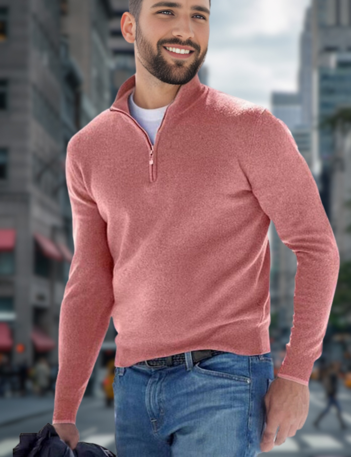 Junger Mann in rosa Pullover und Jeans spaziert lächelnd durch eine belebte Stadtstraße. Urbaner Hintergrund mit modernen Gebäuden.