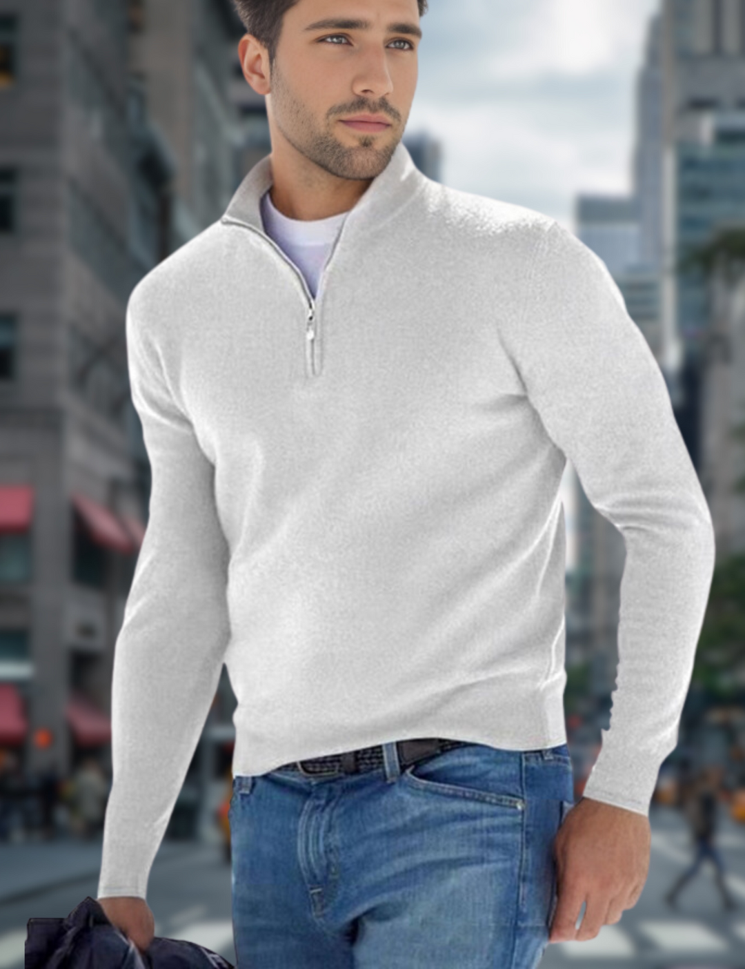 Junger Mann in weißem Pullover und blauer Jeans steht in urbaner Umgebung. Mode, Herrenbekleidung, Stadt, Freizeitlook.
