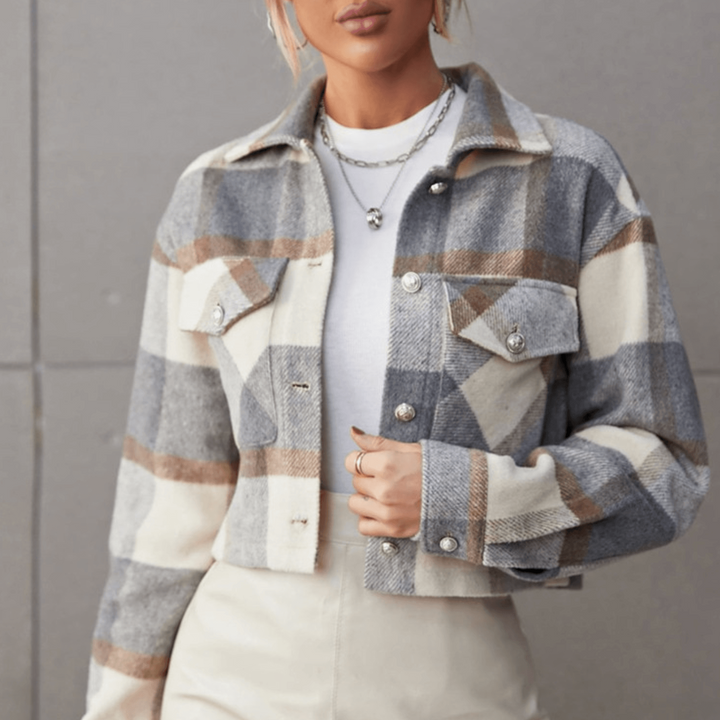 Dame in kariertem Wollmantel, beige und grau, mit weißen Knöpfen. Modetrend Herbst 2023, stilvolle Damenbekleidung, elegante Jacke.