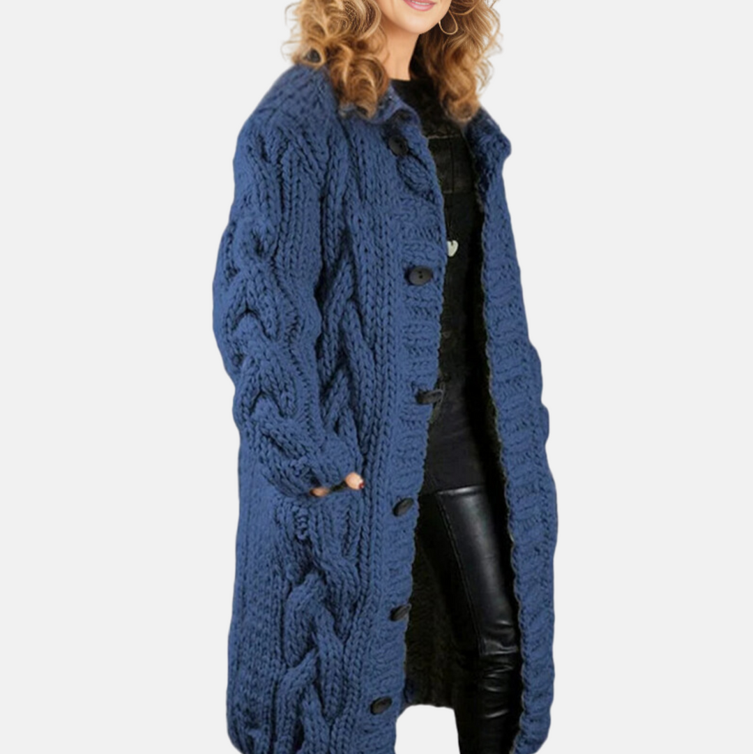 Frau in blauem Strickmantel mit Zopfmuster, lächelt. Modischer Wintermantel, Damenmode, gemütlicher Look. Perfekt für kalte Tage.