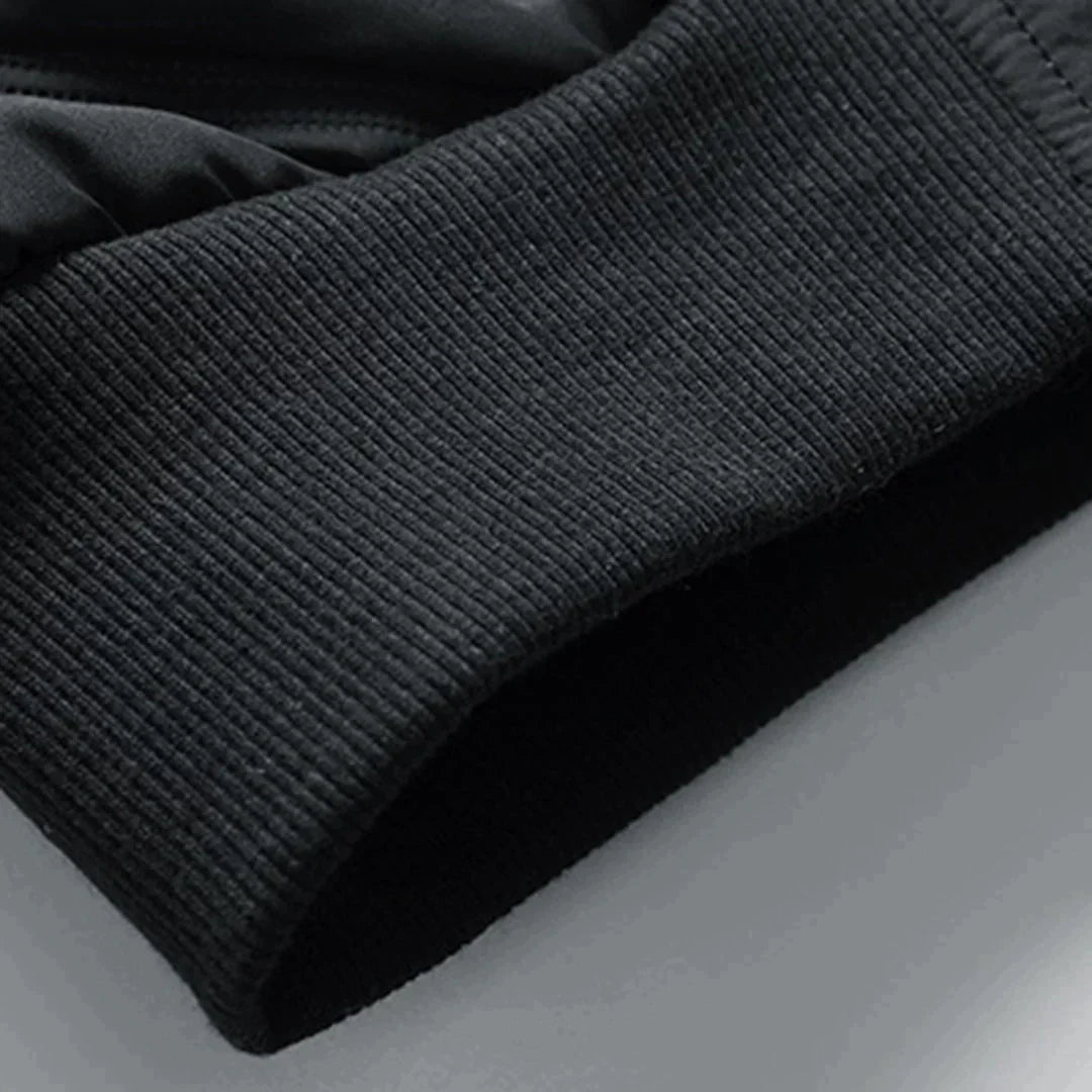 Schwarzer, gerippter Ärmelabschluss eines Sport-Sweatshirts aus Baumwollmischung, Nahaufnahme. Ideal für Fitness, Laufen, Outdoor-Aktivitäten.