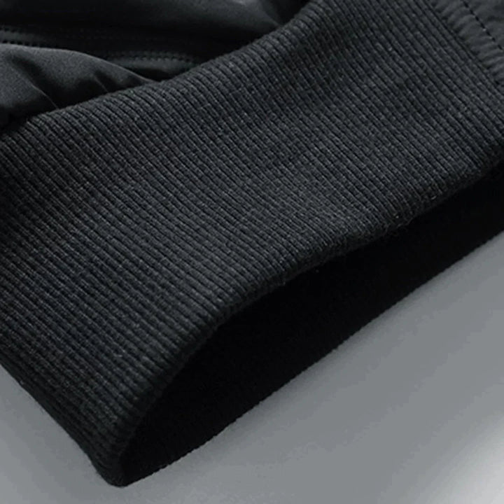 Schwarzer, gerippter Ärmelabschluss eines Sport-Sweatshirts aus Baumwollmischung, Nahaufnahme. Ideal für Fitness, Laufen, Outdoor-Aktivitäten.