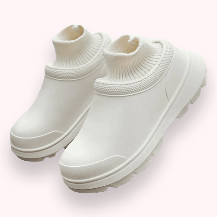 Weiße, moderne Gummistiefel mit gestricktem Schaft, rutschfeste Sohle, stilvoll und funktional, ideal für Regenwetter und Outdoor-Aktivitäten.
