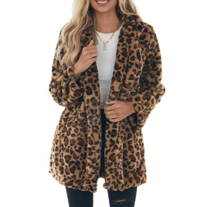 Frau in Leopardenmuster-Mantel, weißem Oberteil und schwarzer Hose. Modetrend, stilvolle Damenbekleidung, Herbst-Winter-Outfit.
