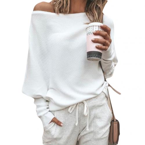 Frau in weißem Pullover und grauer Jogginghose hält Kaffeebecher. Lässige Mode, gemütlicher Look, Freizeitkleidung, Herbstoutfit.
