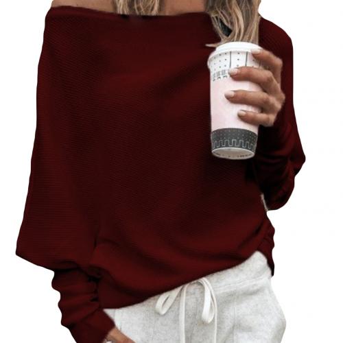 Frau in rotem Off-Shoulder-Pullover hält einen Kaffeebecher. Lässige Mode, gemütlicher Look, Freizeitkleidung, Herbstoutfit.