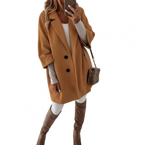 Frau in modischem, braunem Oversize-Mantel mit Knöpfen, weißem Outfit und braunen Overknee-Stiefeln. Trendige Herbstmode, stilvolle Damenbekleidung.