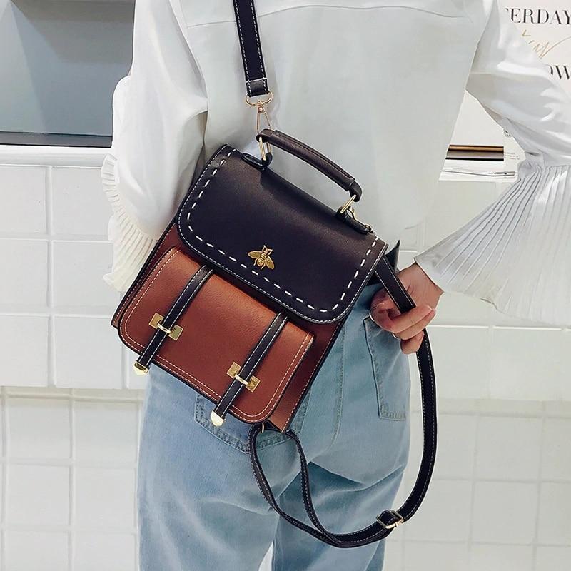 Frau mit modischem zweifarbigem Rucksack, schwarz-braun, Bienenmotiv, in heller Bluse und Jeans. Trendiger Damenrucksack, stilvolles Accessoire.
