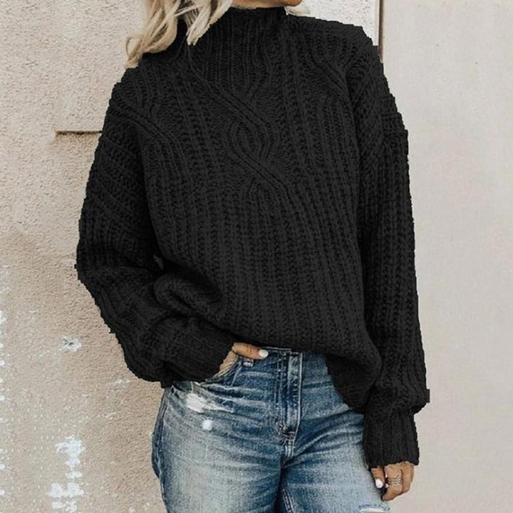 Frau in schwarzem Strickpullover und blauer Jeans vor beiger Wand. Modetrend, Herbstmode, lässiger Stil, Strickmode, Damenbekleidung.