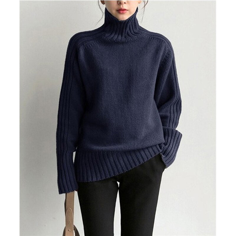 Dunkelblauer Rollkragenpullover aus Strick, lässig geschnitten, getragen von einer Person. Modetrend, Herbstmode, Damenbekleidung.