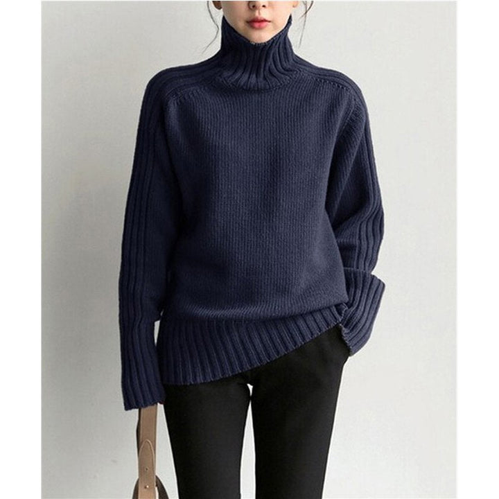 Dunkelblauer Rollkragenpullover aus Strick, lässig geschnitten, getragen von einer Person. Modetrend, Herbstmode, Damenbekleidung.