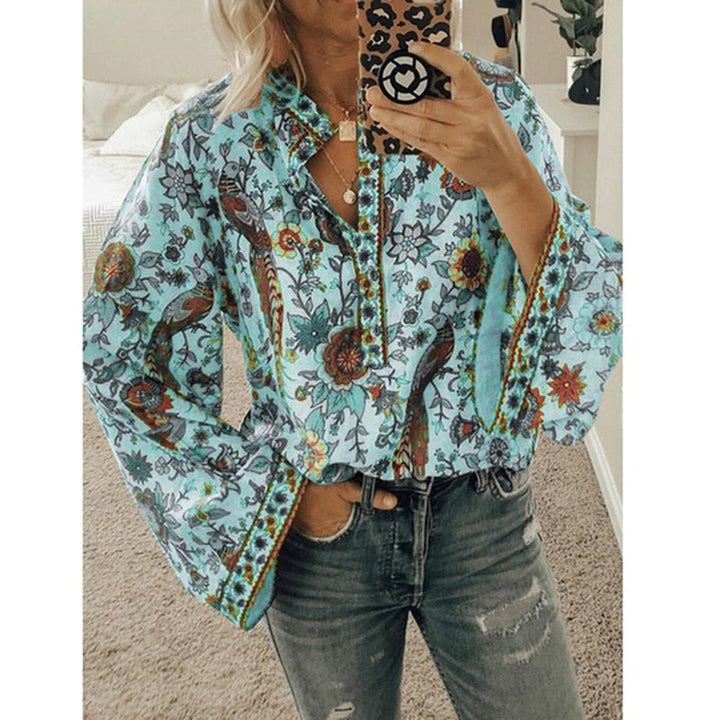 Frau in geblümter Bluse mit langen Ärmeln, hält Smartphone mit Leopardenmuster-Hülle, trägt Jeans. Modetrend, Damenmode, Freizeitlook.